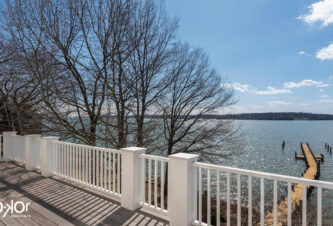 Residential project with a balcony with a  waterfront view by DKOR Interiors.