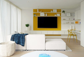 Multifunctional room ideas showcasing a family room and playroom design with a wall-mounted tv, sectional couch, and a desk area.