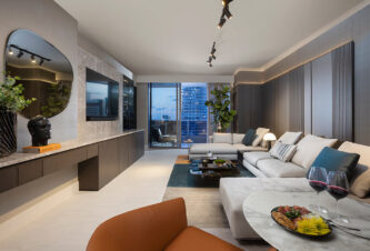 Un diseño de sala de estar de concepto abierto con un comedor incorporado en el sofá y un bar incorporado y almacenamiento de TV en un condominio Flatiron Brickell.