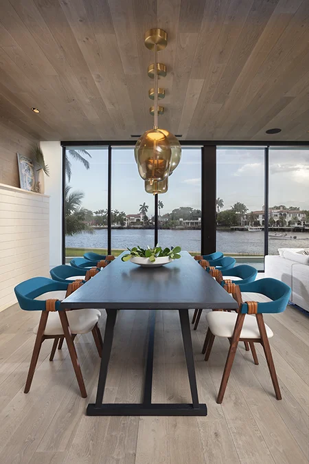 Dining room with a pop of color in a Florida waterfront residence