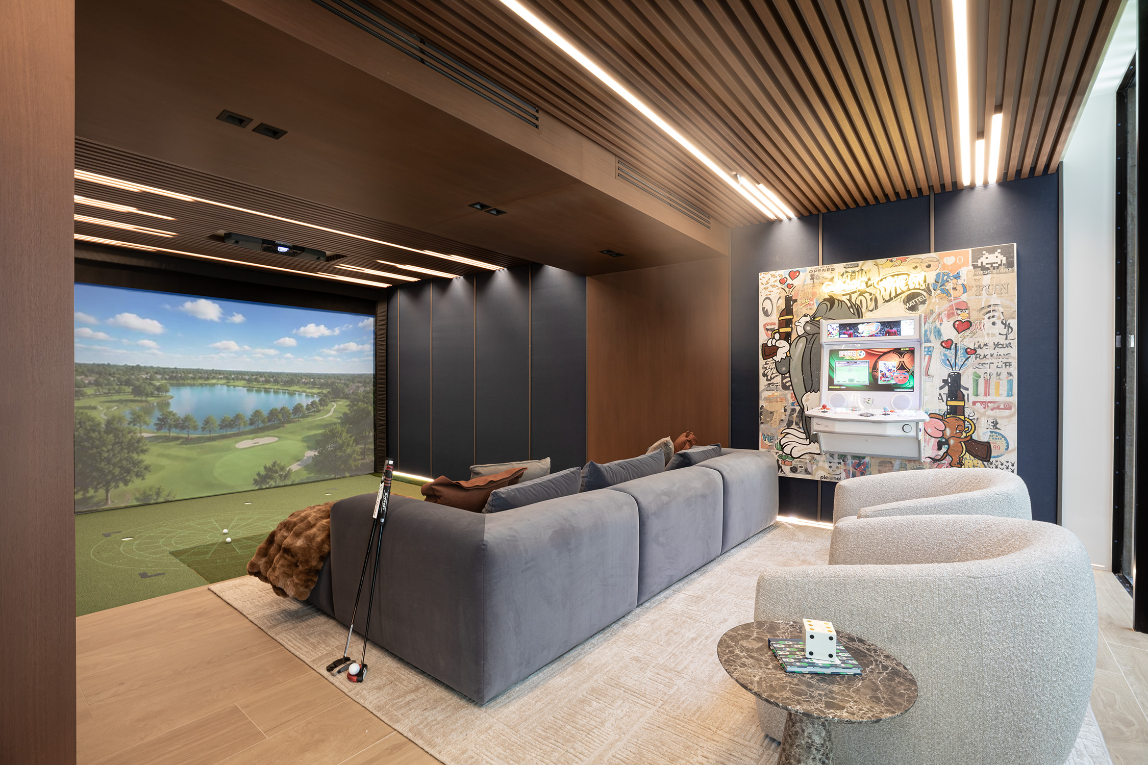 Golf simulator room and arcade lounge in a Venetian Islands home by DKOR Interiors