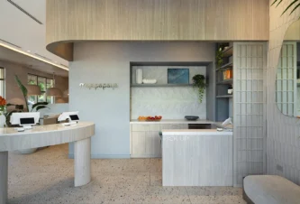 Fort Lauderdale restaurant pickup area with curved light wood counters, open shelving, terrazzo flooring, and branded signage