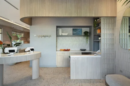 Fort Lauderdale restaurant pickup area with curved light wood counters, open shelving, terrazzo flooring, and branded signage