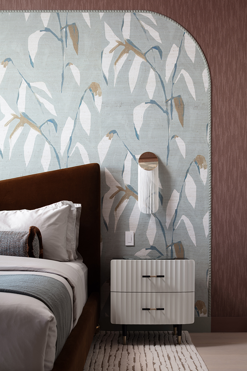 Close-up of leaf pattern wallpaper framed in custom moldings paired with textured wallcovering.