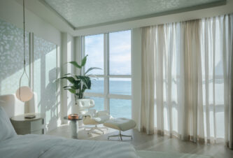 A living room showcasing modern coastal interior design with natural light and oceanfront views in Bal Harbour.