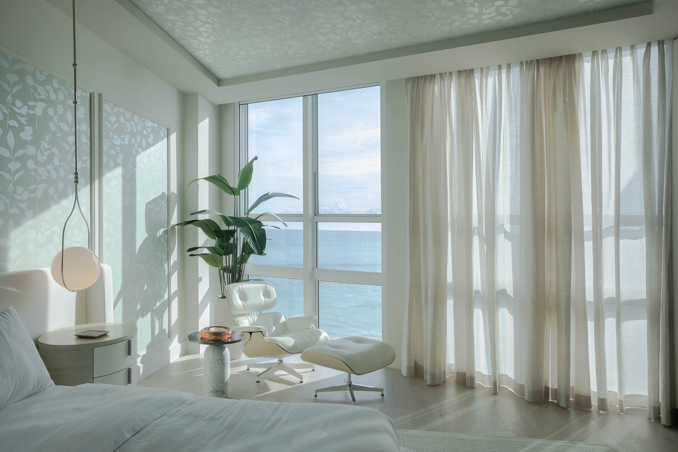 A living room showcasing modern coastal interior design with natural light and oceanfront views in Bal Harbour.