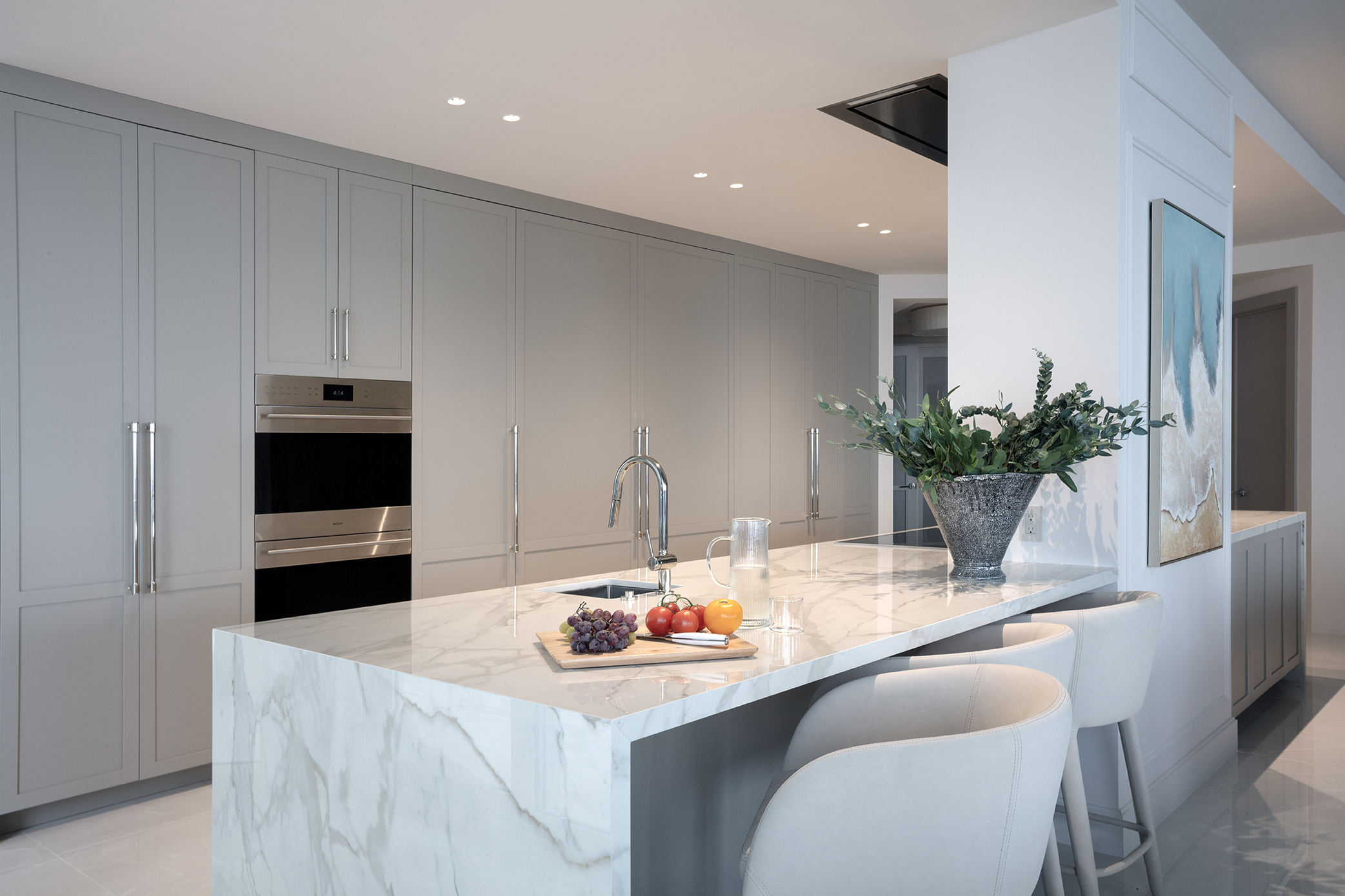 Modern coastal interior design elements, including a marble kitchen island, a vanity nook, and a luxury bedroom with textured walls.