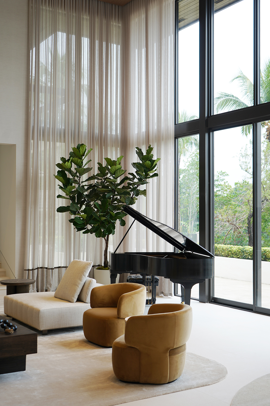 Airy seating area with double-height sheer curtains and neutral furniture in a Coral Gables luxury home renovation.