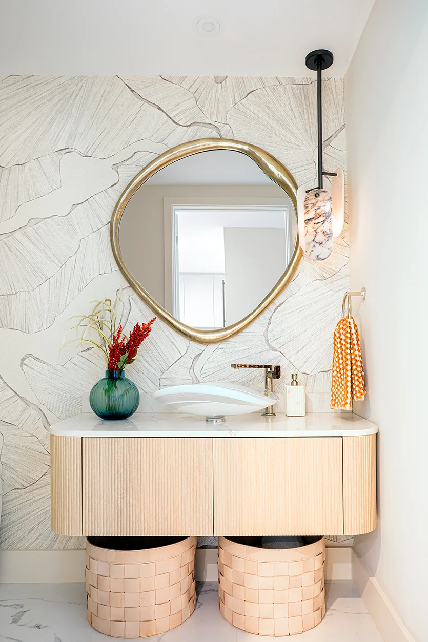 powder room with organic modern interior design featuring gold mirror and leaf wallpaper