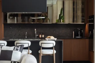 Existing kitchen with walnut cabinetry and dark marble connected to the bar and dining area, Miami Beach interior design